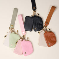 The Darling Effect Blush Dynamic Duo Pouch Luxe Wristlet includes four sets in green, pink, black, and brown. Each set offers textured and smooth pouches with gold zippers, a key ring, and a matching fabric wrist strap for hands-free use.
