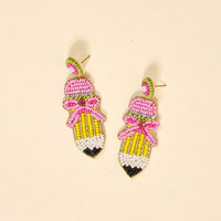 Add a playful touch to your jewelry collection with The Darling Effect's Pencil Me In Beaded Earrings—pencil-shaped, hand-beaded with pink tips, yellow barrels, green beads, and pink bows for extra charm.