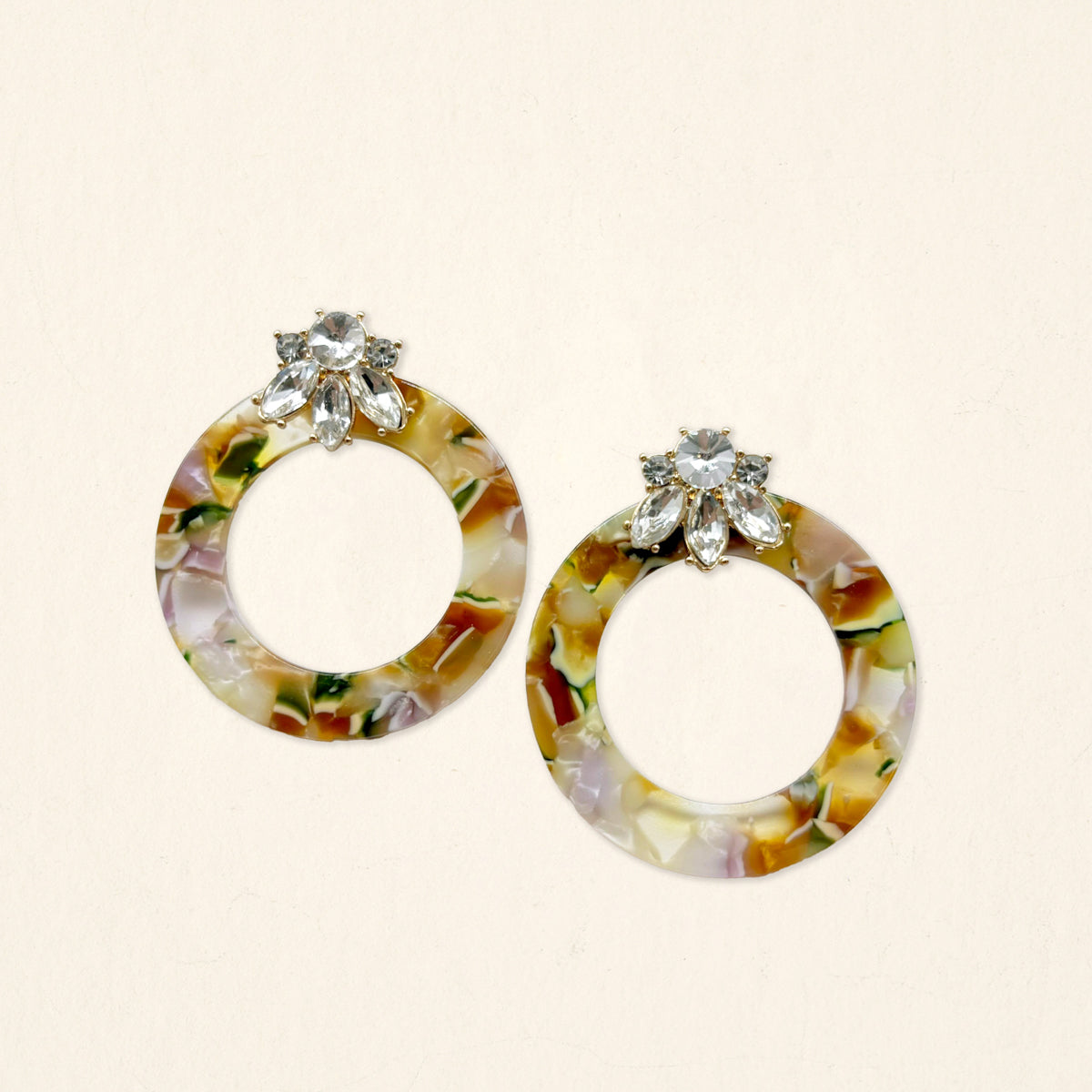 The Darling Effect’s Amber Drift Glow Getter Earrings feature multicolor tortoiseshell hoops in cream, amber, and green with crystal rhinestone floral studs—glossy acetate, lightweight, and perfect for any occasion.