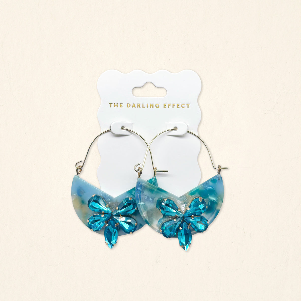 A pair of Sea Glass Marble Bloom Hoop Earrings by The Darling Effect, featuring lightweight hoop design with marble-like accents, displayed on a branded card against a light background.