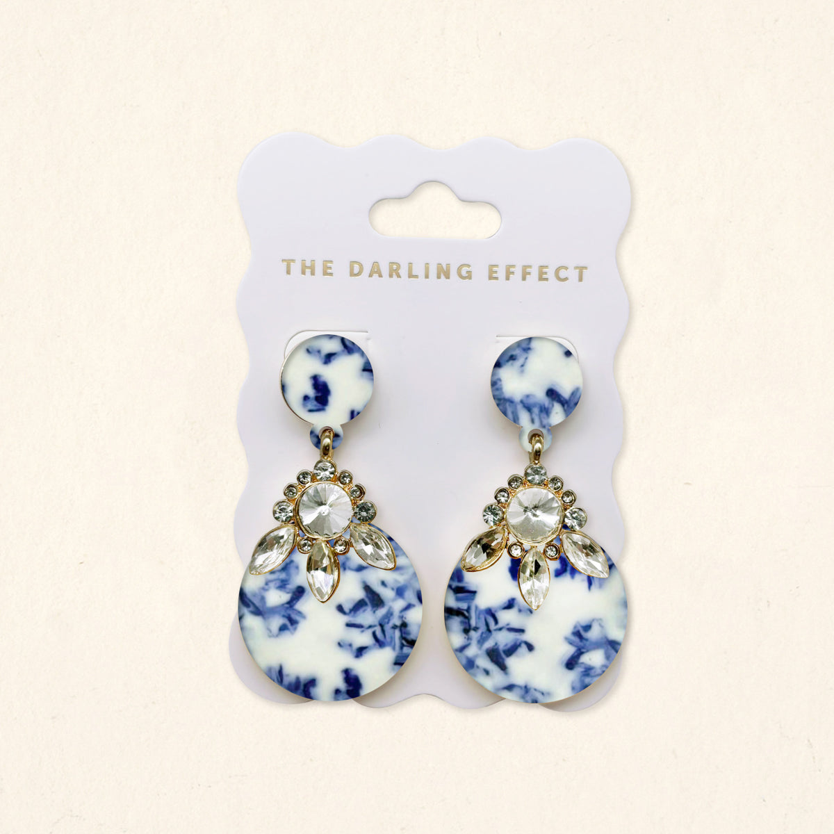 The Darling Effect’s Chinoiserie Flair Show Stopper Earrings feature blue and white marbled resin with rhinestones. Lightweight for all-day comfort, they arrive elegantly displayed on a white card, perfect for making a modern statement.