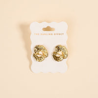 The Ripple Effect Standout Earrings by The Darling Effect feature a textured heart design and are displayed on a white card with brand text, set against a cream background—stylish statement jewelry for any occasion.