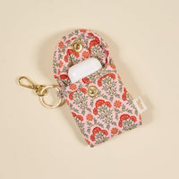 The Darling Effect Everbloom Dusty Rose Puffy Earbud Case, featuring a floral design and gold snap closure, is displayed on a beige background—ideal for carrying your wireless earbuds in style every day.