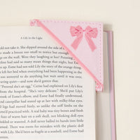 The Darling Effect’s Oh So Fancy Pink Corner Keeper Fabric Bookmark, with its stitched bow and quilted design, secures the top right corner of your page—a thoughtful gift for book lovers, shown on a light neutral background.