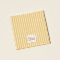 The Darling Effect’s “I’d Rather Be Reading” Corner Keeper Fabric Bookmark features yellow and white stripes with a stitched label, making it a perfect gift for book lovers or a stylish accent for your reading routine.
