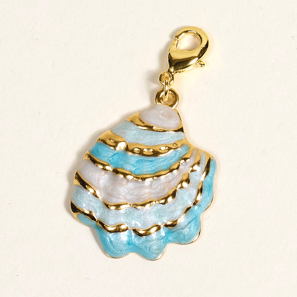 The Darling Effect's Blue Shell Beauty Jewelry Charm Gold features gold-accented blue and white enamel stripes with a gold lobster clasp—ideal for your charm bar or collection. Shown on a light background.