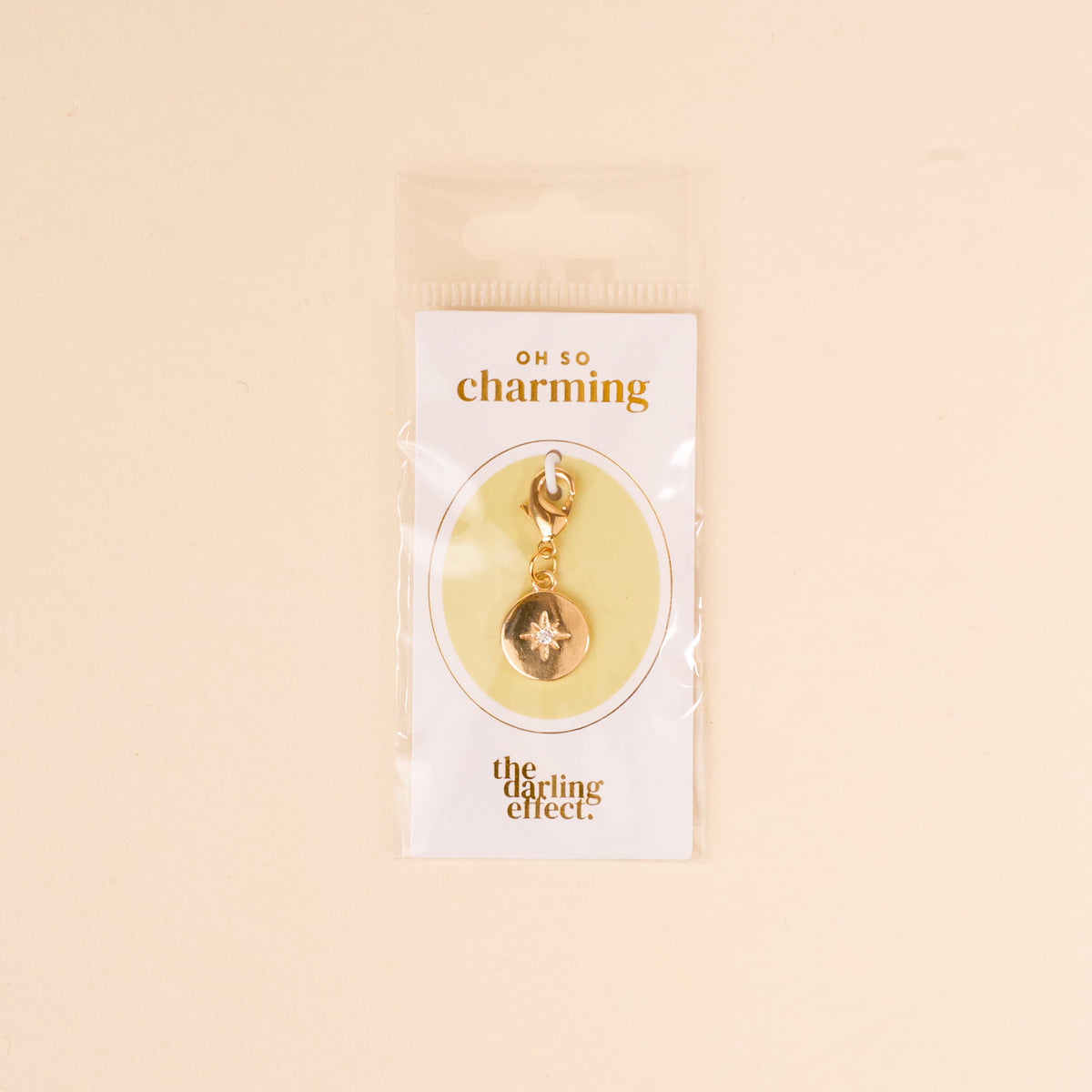 The Compass Jewelry Charm Gold by the-darling-effect comes on a white card labeled 'OH SO charming' and is packaged in a clear bag—an ideal addition to your charm bar collection.