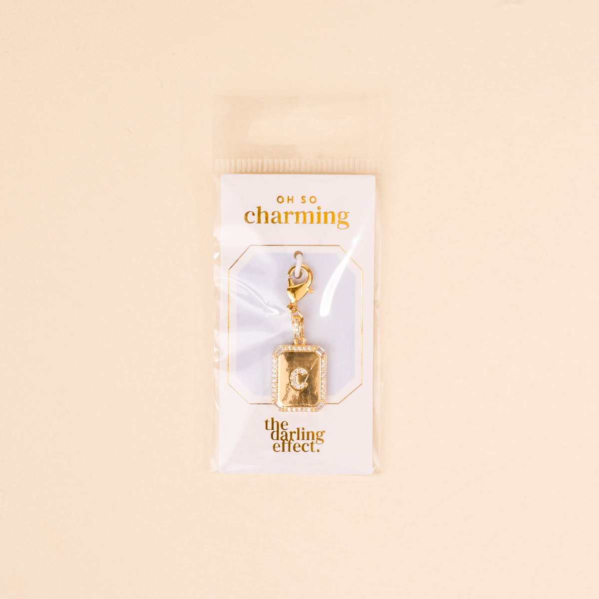 The C Jewelry Charm Initial Letter Gold by the-darling-effect is a gold-plated charm, perfect for personalized jewelry. It comes on an OH SO charming card, packaged in clear plastic with a light beige background.