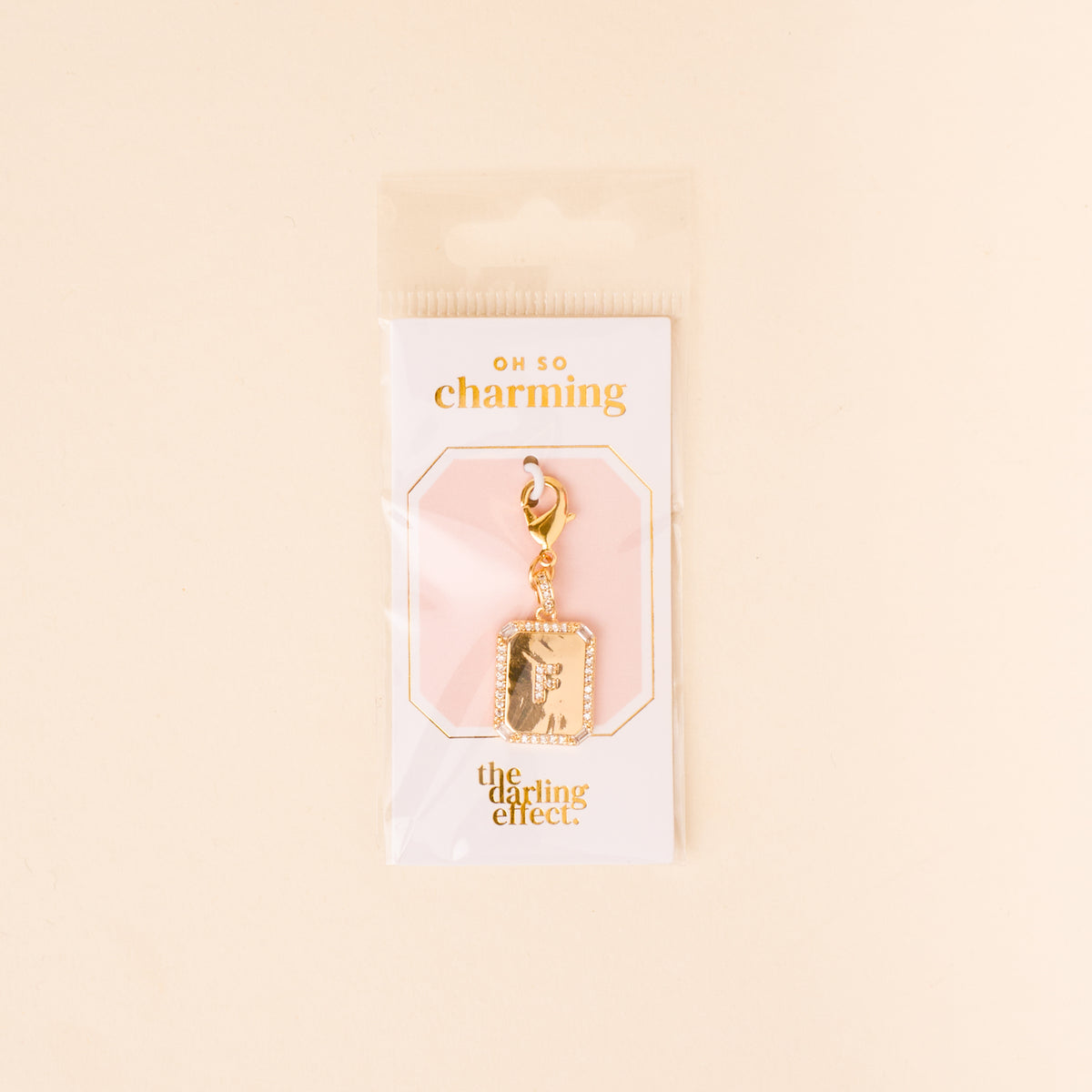 The F Jewelry Charm Initial Letter Gold by the-darling-effect is a gold-plated rectangular pendant with a clasp, packaged on an "OH SO charming" card. Perfect for anyone who loves personalized jewelry.