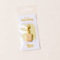 The-darling-effect's G Jewelry Charm Initial Letter Gold features a rectangular gold-plated brass charm with a central clear gem on a keyring, packaged on an "Oh so charming" card and photographed against a light background.