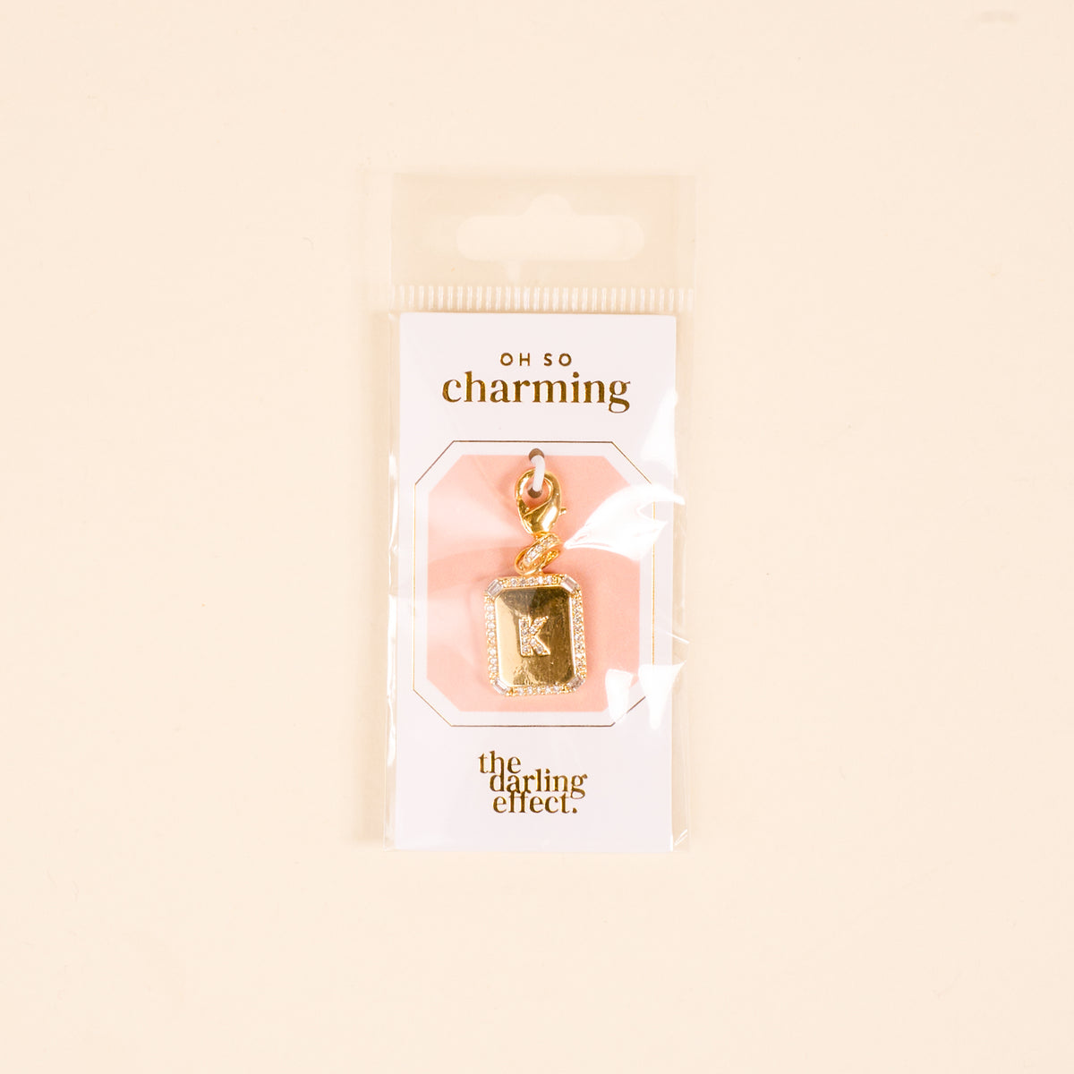 The-darling-effect K Jewelry Charm Initial Letter Gold, gold-plated and perfect for personalized jewelry, comes in rectangular OH SO charming packaging on a light beige background.