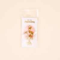 The Darling Effect's Lobster Love Jewelry Charm Gold features a lobster-shaped design with a clasp, packaged in a clear bag that reads "OH SO charming" and "The Darling Effect"—perfect for your charm bar or layering necklace.