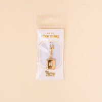 The-darling-effect N Jewelry Charm Initial Letter Gold features a gold-plated brass M encrusted with small gems and a lobster clasp, displayed on an OH SO charming card in clear packaging.