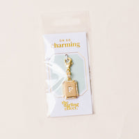 The-darling-effect P Jewelry Charm Initial Letter Gold features a gold-plated brass "P" on a card reading “OH SO charming” and “the darling effect.” This personalized charm comes in clear plastic packaging.