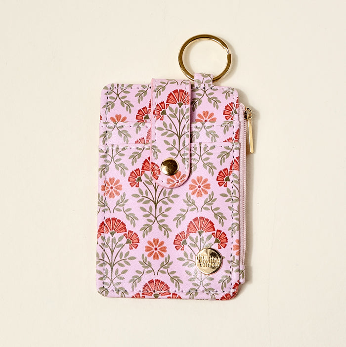The Darling Effect's Everbloom Dusty Rose Keychain Wallet features a pink floral pattern, gold keyring, snap-button closure, and zippered coin holder, shown on a light background.