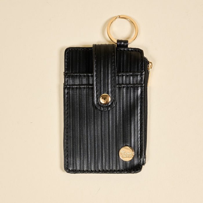 The Darling Effect Black Ripple Ridge Keychain Wallet features a black vertical-striped design, snap closure, gold zipper, and gold keyring—perfect as a stylish zippered coin holder or compact wallet.