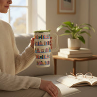 A person holds The Darling Effect Book Shelfie 20 oz Lifestyle Flip Straw Tumbler, featuring insulated stainless steel and a design of bookshelves filled with colorful books and plants.