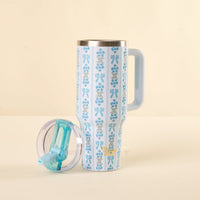 The Oh So Fancy Blue 40 oz Lifestyle Flip Straw Tumbler by the-darling-effect features a white body with blue floral pattern, large handle, and a clear leak-resistant lid with blue sliding closure—perfect for travel.