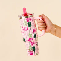 A hand holds the-darling-effect Pickleball Party 40 oz Lifestyle Flip Straw Tumbler, featuring a handle, a leak-resistant red flip straw lid, and a vibrant green and pink pickleball paddle pattern.