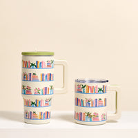 Two white "Book Shelfie" insulated mugs by The Darling Effect rest on a white surface, each featuring colorful bookshelf illustrations. The 14 oz mug has a green lid, while the shorter one has a clear lid and double-wall insulation.