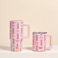 Two Oh So Fancy Pink 14 oz Insulated Mugs by The Darling Effect sit side by side, each with a handle, light pink lid, pink bow and floral pattern, and double-wall insulation to keep drinks hot or cold.