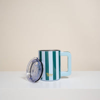 The Darling Effect Sicily Stripes Teal 14 oz Insulated Mug, with blue and green stripes and a light blue handle, sits next to its clear lid on a white surface. Double-wall insulation keeps drinks at the perfect temperature.