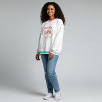 Young woman with curly dark hair wearing The Darling Effect Mahjong Social Club Oversized Crew and jeans, standing against a light gray background.