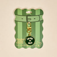 The Darling Effect’s Too Cute for Rules Pawfect Collar Charm adds playful style to any pet collar—featuring a gold charm on a green card with cartoon dog and cat outlines, perfect for accessorizing your furry friend.