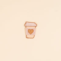 The Darling Effect's Coffee Cup Mix & Match Iron-On Patch features a light pink embroidered cup with a golden heart on a light yellow background—perfect for adding colorful flair to your collection.