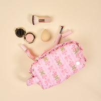 The Darling Effect’s Oh So Fancy Pink Essentials Quilted Cosmetic Pouch features pink florals and ruffle trim—ideal for travel and storing your beauty essentials like brushes, sponges, compacts, and lip products.