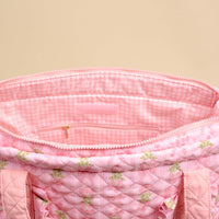 The Darling Effect’s Oh So Fancy Pink The Everyday Quilted Tote Bag features a floral print, trolley sleeve, pink gingham lining, and zippered pocket.