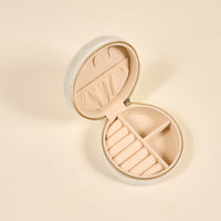 The Darling Effect's Bride Round Velvet Jewelry Case features a light cream finish, soft beige interior, multiple compartments for rings and accessories, and an elastic lid pocket—an elegant travel organizer for jewelry.