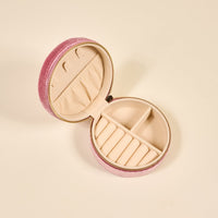 The Darling Effect Poppin' Petals Hot Pink Round Velvet Jewelry Case features a zippered design and multiple cream compartments to organize and protect your accessories on the go.