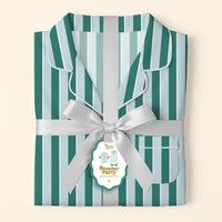 The Darling Effect’s Sicily Stripes Teal Slumber Party Pajama Pants Set, featuring teal and light blue stripes and crafted from ultra-soft fabric, is tied with a silver ribbon and a “Slumber Party Pajama Set” tag on a pale background.