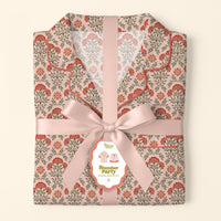 The Darling Effect’s Everbloom Dusty Rose Slumber Party Pajama Shorts Set features a pink and red floral pattern, tied with a wide pink satin ribbon and bow, plus a tag showcasing the relaxed fit and ultra-soft fabric.