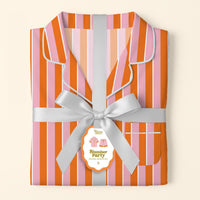 Folded Sicily Stripes Pink Slumber Party Pajama Shorts Set by The Darling Effect, featuring pink, orange, and red stripes, silver ribbon and tag, ultra-soft fabric, white piping on collar and edges for a relaxed fit.