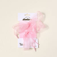 A pair of sheer pink Step It Up Shoelaces by The Darling Effect, tied into bows and displayed on white packaging labeled “shoelaces.”.