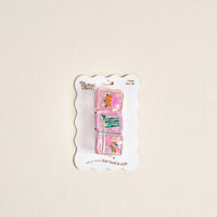 The Darling Effect Mahjong Tiles Shape Up Claw Clip set features three pink, translucent clips with colorful floral designs on a scalloped white card—ideal for adding charm to any cute hairstyle.
