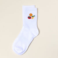 The Darling Effect Fruit Market Embroidered Crew Socks are white with orange slice, strawberry, and lemon wedge designs near the top, shown on a plain light background.