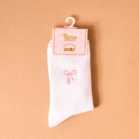 Add a charming pop to your outfit with The Darling Effect Pink Bow Embroidered Crew Socks, featuring white ribbed fabric and a pink embroidered bow on the ankle.