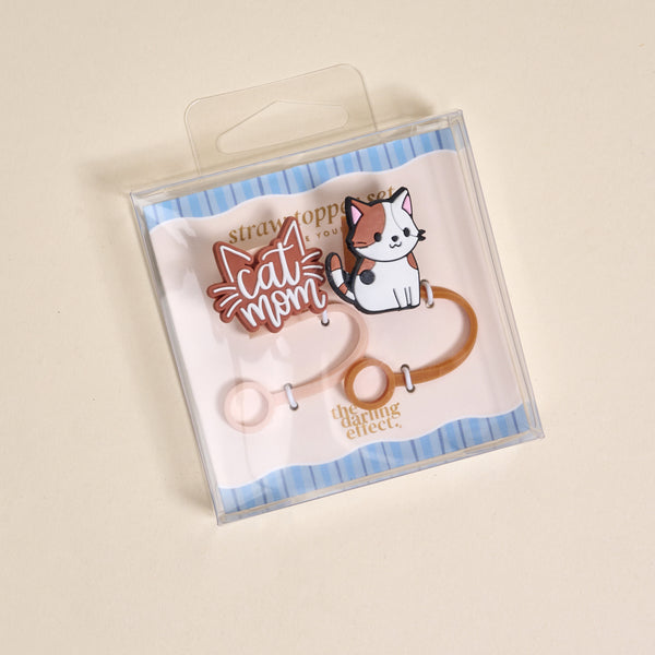 The Darling Effect Cat Mom Straw Topper Set includes leak-resistant silicone toppers with a "Cat Mom" design and cute white cat illustration, displayed on blue-striped backing—perfect drinkware accessories for cat lovers.