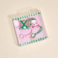 The Darling Effect Par-tee Pack Straw Topper Set includes two silicone toppers—one shaped like crossed golf clubs with a ball, the other a pink golf cart—on a pink and green striped card in a clear box.