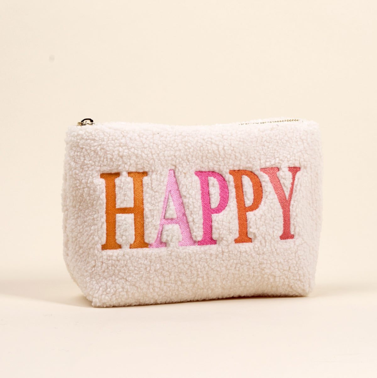 The Darling Effect's Happy Edit Teddy Pouch is a small, white sherpa zippered pouch with "HAPPY" embroidered in orange and pink, shown on a beige background—perfect for your accessory collection of teddy pouches.