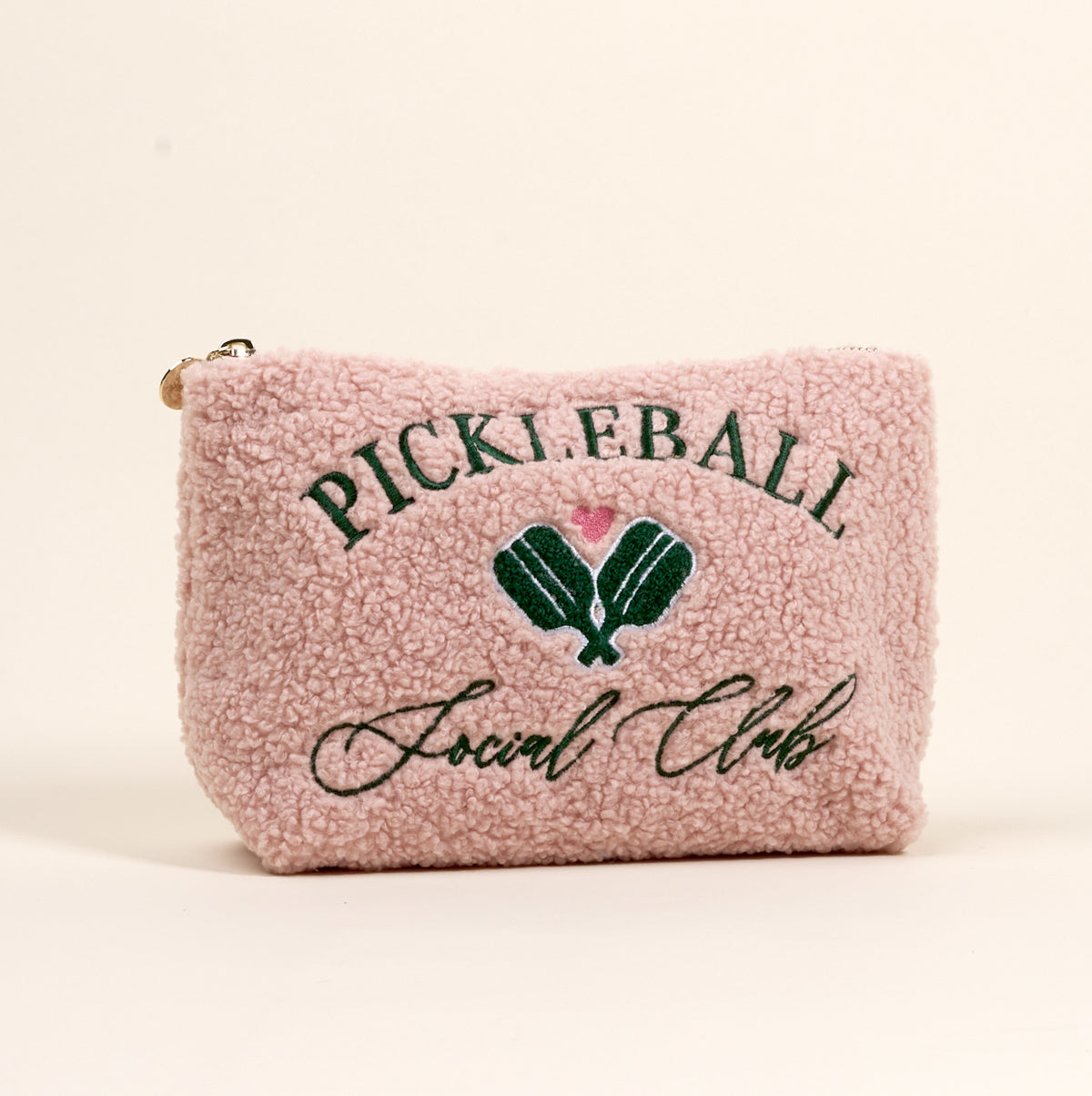 The Darling Effect’s Pickleball Social Club Teddy Pouch features pink sherpa fabric, green “PICKLEBALL Social Club” text, and embroidered green paddles with a pink heart—an adorable must-have accessory.