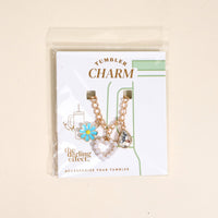The Darling Effect’s Fairytale Tumbler Charm set features a blue daisy, pearl heart, and crystal teardrop on gold chains—the ideal way to add flair to your favorite tumbler.