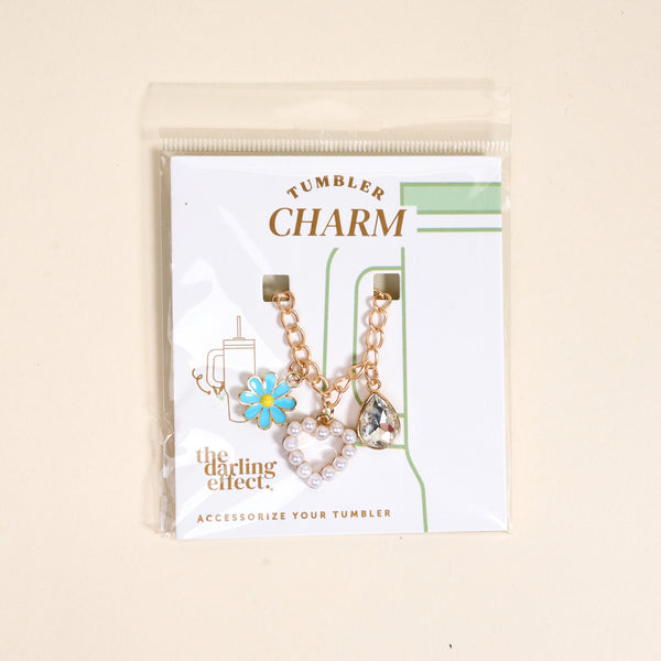 The Darling Effect’s Fairytale Tumbler Charm set features a blue daisy, pearl heart, and crystal teardrop on gold chains—the ideal way to add flair to your favorite tumbler.