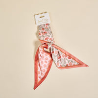 The Darling Effect Everbloom Dusty Rose Twirl & Tie Scarf Accessory features pink and green floral prints, packaged for gifting, adding boutique charm and versatile style to any outfit.